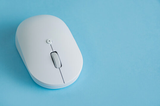 White wireless computer mouse on blue