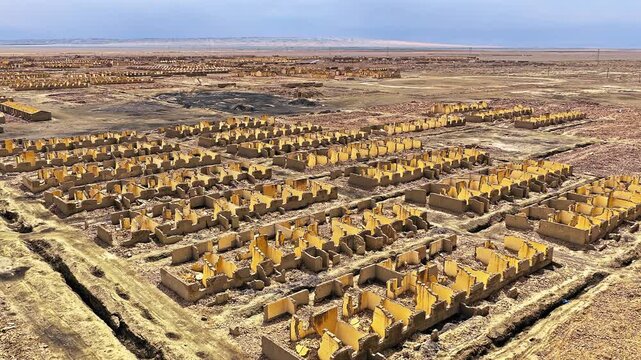 High angle view reveals extensive abandoned mud brick structure ruins spanning across the vast desert landscape at Lenghu Oil Base Site, Qinghai.