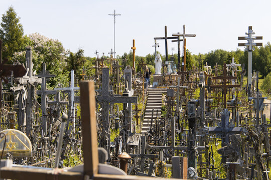 View of the Hill of Crosses featuring thousands of wooden and metal crosses, a stone staircase, and a statue of the Virgin Mary in Hill of Crosses, Siauliu Apskritis, Lithuania.