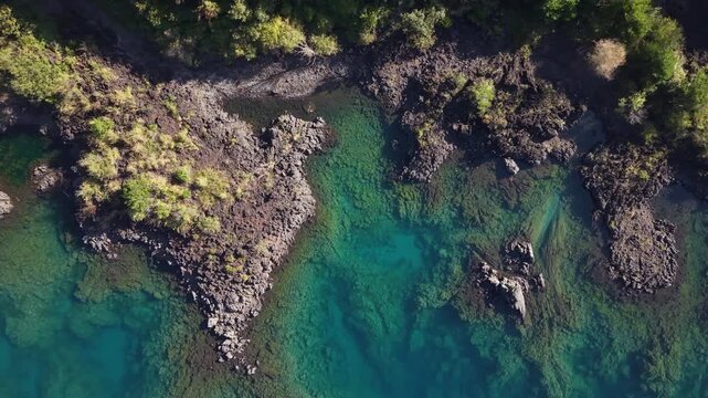 山梨県富士五湖の１つ「本栖湖」の溶岩湖岸の上空をカメラを真下に向けて上昇した空撮映像