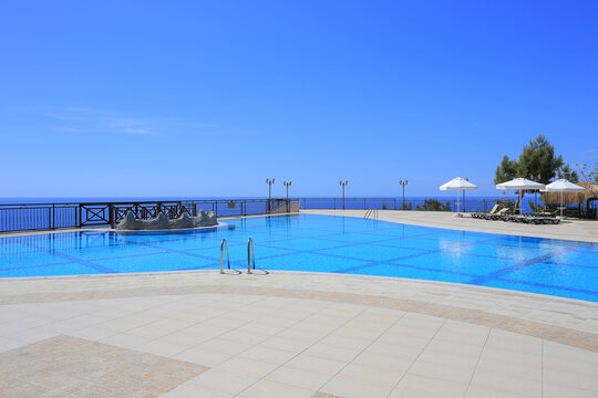 Large luxury outdoor swimming pool with an endless sea horizon view