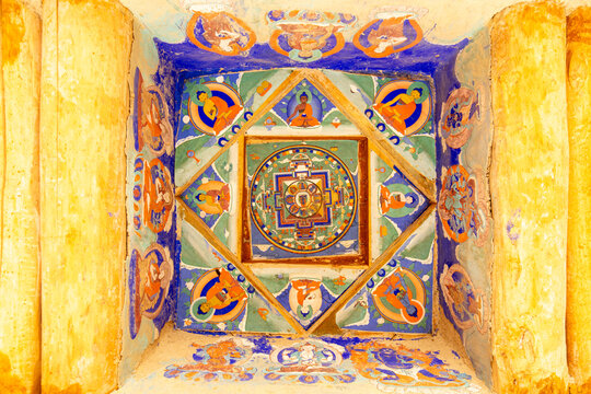 View of an intricate mandala ceiling painting with vibrant colors and Buddhist deities inside a monastery in Zanskar, Ladakh, India.