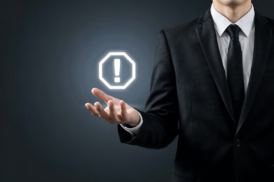 Businessman holding glowing exclamation mark icon above palm representing warning alert or important business notification