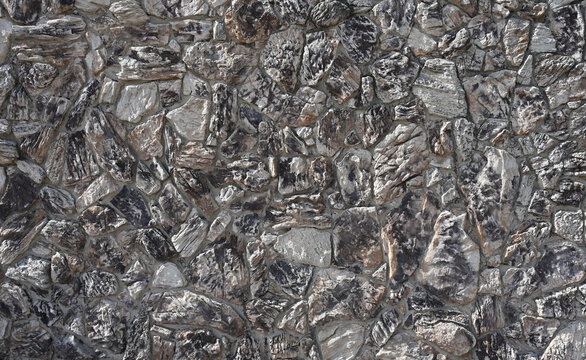 Multi-textured rock wall of large cut stones with rough porous faces, deep crevices, cracks, raised ridges and recessed gray mortar, with varied mineral coloration and alternating sunlight and shade