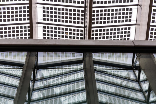 View of the modern glass and steel roof structure of Rotterdam Centraal, featuring geometric patterns and natural light filtering through the panels, Rotterdam, South Holland, Netherlands.