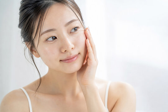 頬に手を添える女性の美容ポートレート