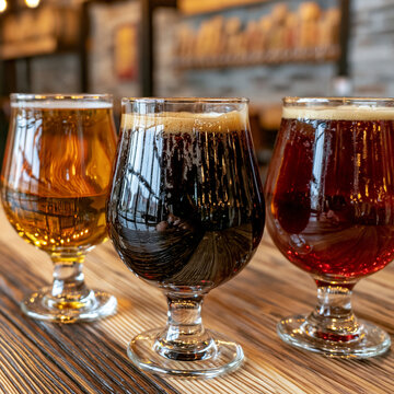 Selection of artisanal beer glasses on a rustic wooden counter with craft bar
