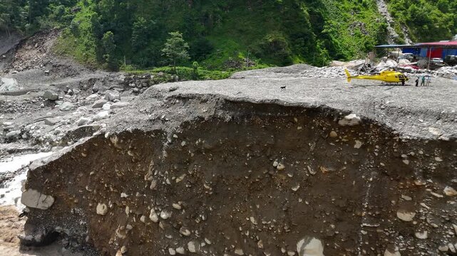 Kathmandu, Bagmati Province, Nepal - 31 August 2026: Aerial view of Mailung Khola Jal Vidhyut site showing landslide damage with a yellow helicopter parked on the debris.