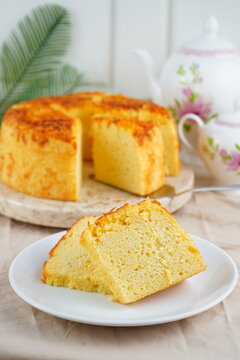 Homemade Golden Cheese Sponge Cake with Sliced Pieces Served on White Plate