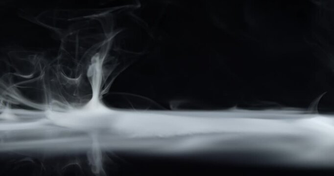 Real wispy fog rolling and blowing away. Spooky stage filled with a haze of stormy smoke swirling from side to side for a ghostly aura of the mysterious or an eerie Halloween background visual effect