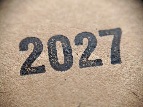 Happy new year 2027 written in the sand on a beach with a shallow depth of field