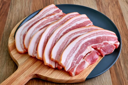 Raw pork belly slices displaying marbled meat and fat