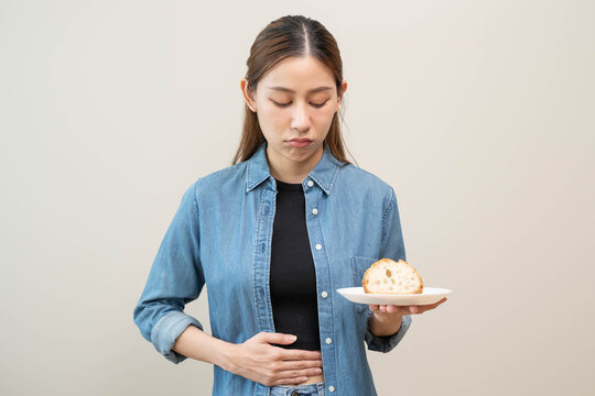 Gluten intolerance person, person holding plate on bread and feeling pain in stomach.
