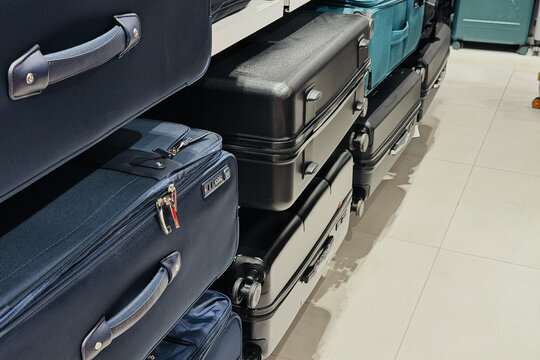 Stack of multiple luggage bags in a row on a tiled floor