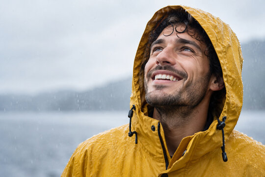 Junger Mann lacht im Regen