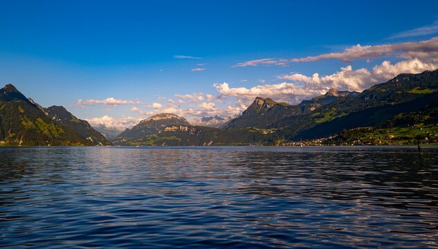 Lake Lucerne view across Canton Schwyz. Lake nature panorama with alpine cloudscape. Brunnen destination beside Lake Lucerne in Switzerland. Swiss summer travel around Lake Lucerne.