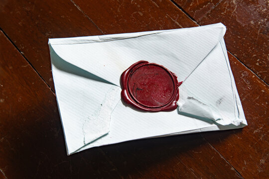 Intentional Vintage Blue Envelope Sealed with Red Wax Stamp Resting on Rustic Wooden Parquet Floor