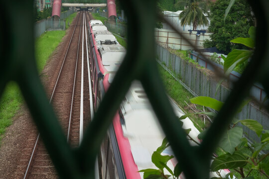 Train Moving on Tracks Seen Through Fence