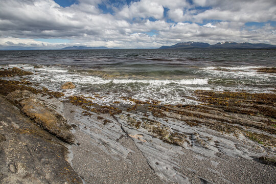 Rugged rocky coastline with crashing waves and cloudy dramatic sky over the atlantic ocean, landscape Patagonia.