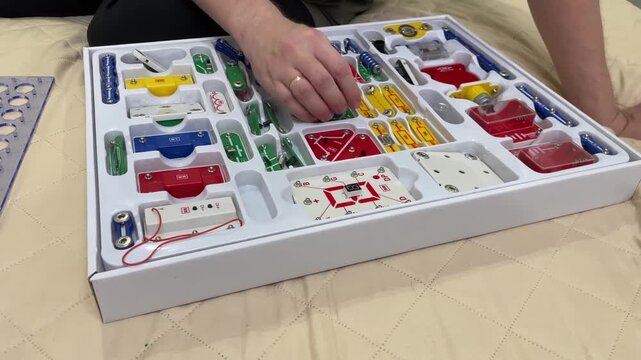 Circuit creation process. Beginnerfriendly guide to constructing circuit grids with focused attention. Methodical assembly of electronic modules on grid using colorcoded components and templates