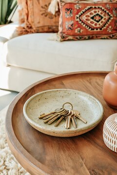 Brass House Keys in Ceramic Dish on Wood Coffee Table in Bohemian Living Room