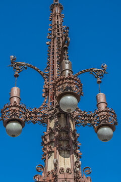 Barcelona, Spain - February 27, 2022: Ornate Art Nouveau lamppost by Pere Falqu&eacute;s i Urp&iacute; on Avinguda de Gaud&iacute;, crafted in wrought iron and stone in the Catalan Modernist style.