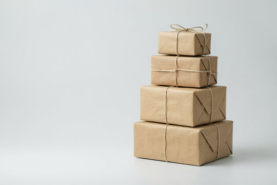 Four kraft parcels stacked largest to smallest on white