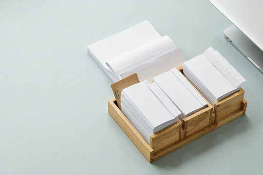 Blank paper sorted into the trays of an oak desk sorter