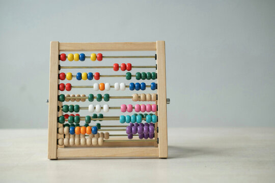 A wooden abacus with rows of coloured counting beads