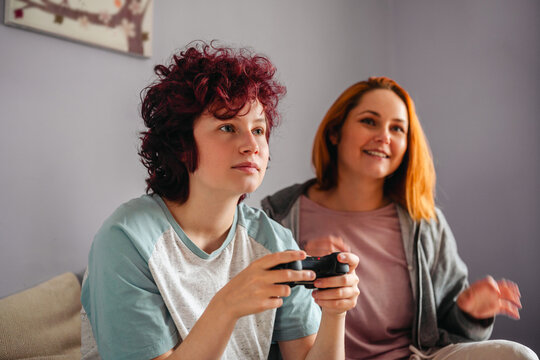 Mother and daughter relaxing together while playing video games