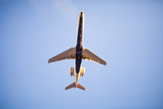 Passenger jet flying overhead against a blue sky