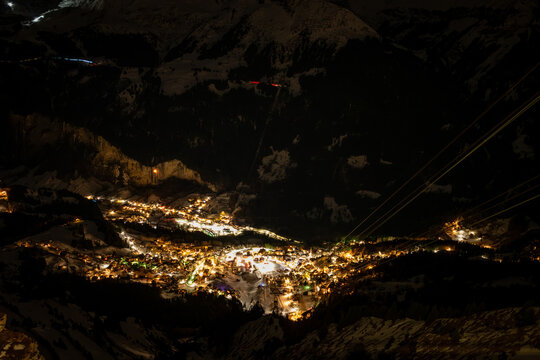 Aerial view of illuminated Wengen, Switzerland at night in winter seen from Maennlichen top station