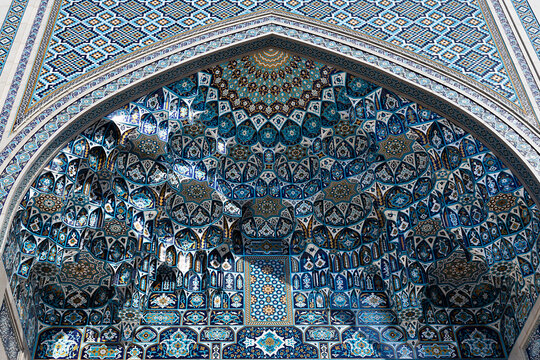Muqarnas vault with intricate blue tilework inside a pointed arch at the Islamic Civilization Center in Tashkent, Uzbekistan. Ideal for travel publications, architecture features, cultural heritage.