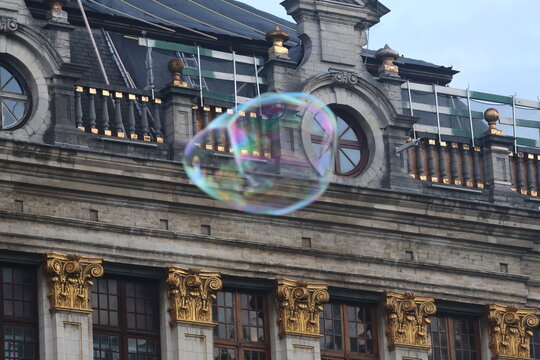 Soap bubble floating in front of ornate guild house in Grand Place, Brussels
