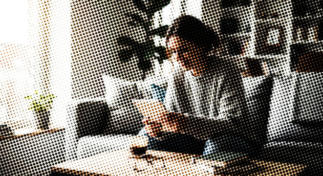 A person using a tablet device in a bright room in a halftone dot halftone effect