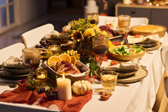 Festive Thanksgiving dinner table served with roasted meat, wine, salad, pumpkin pie, and autumn decorations. Ideal for holiday catering, family celebration promotions