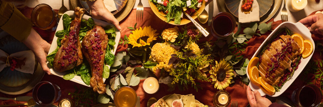 Top view of Caucasian hands serving festive holiday dinner dishes during Thanksgiving celebration. Commercial visual asset for autumn dining and festive food marketing campaigns