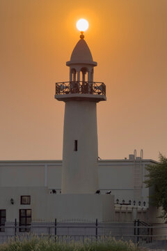 Doha, Qatar - August 10, 2026: Silhouette of Minarte aligned with the glowing sunset sun, dramatic golden sky sunset view. wakrah Qatar