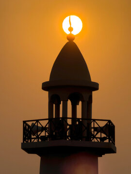 Doha, Qatar - August 10, 2026: Silhouette of Minarte aligned with the glowing sunset sun, dramatic golden sky sunset view. wakrah Qatar