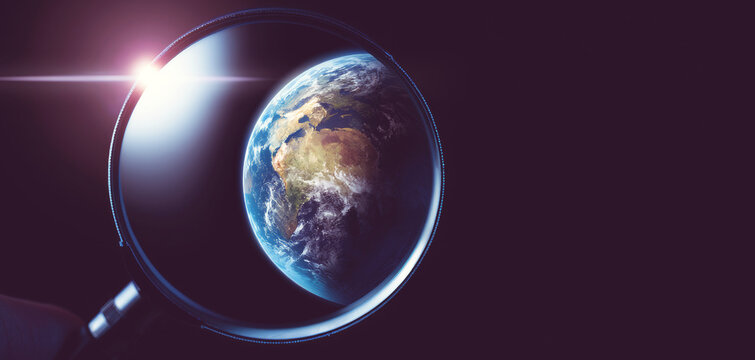 Earth, magnified through a lens, glowing against dark space and representing global research, discovery, and environmental science