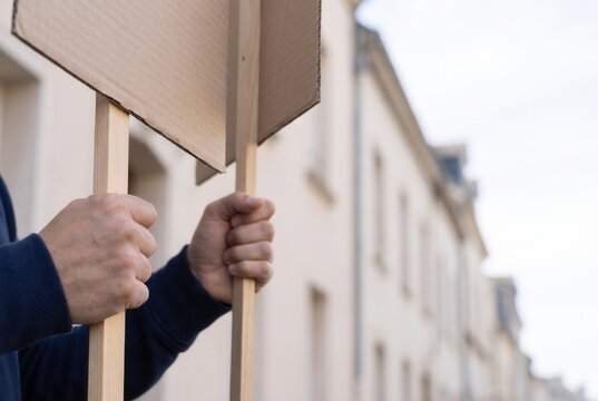 Close up of hands gripping blank protest signs