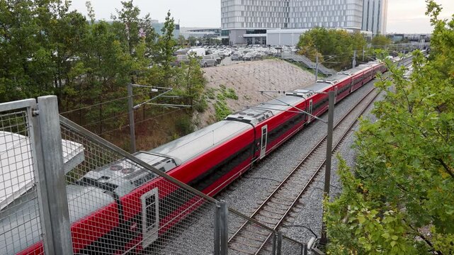 Passenger train traveling on railway tracks near Copenhagen Airport, Denmark