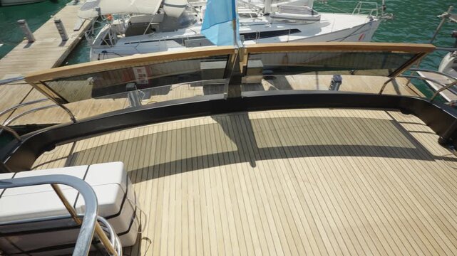 Empty Wooden Aft Deck of a Luxury Yacht Moored in a Marina on a Sunny Summer Day