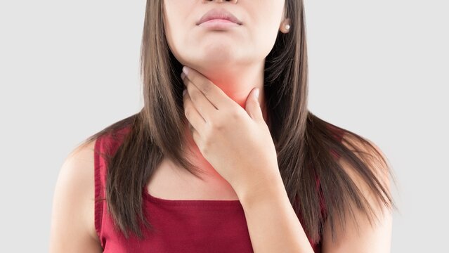 Woman touching her neck experiencing sore throat pain.
