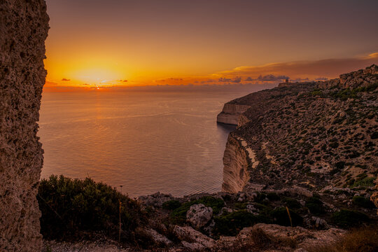 Sunset View of Dingli Cliffs Plunging into the Mediterranean Sea Framed by Natural Rock at Golden Hour, Malta