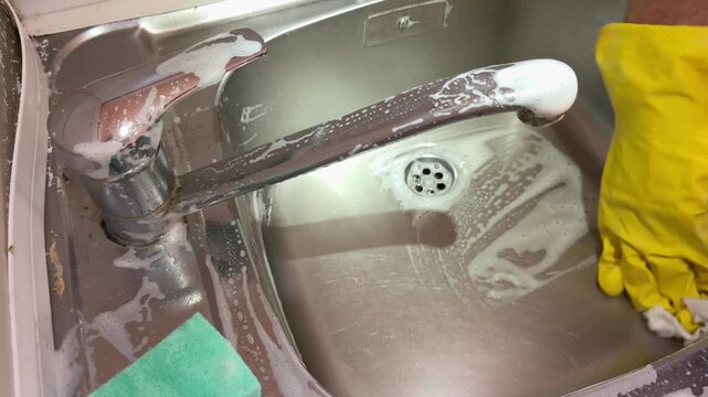 Wiping Soap Foam from Stainless Steel Sink with Cloth