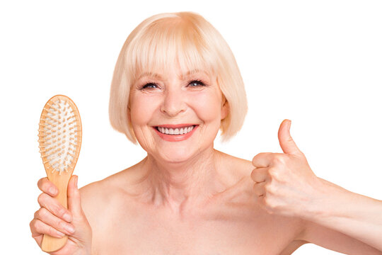 Close-up portrait of her she nice nude naked well-groomed confident cheerful cheery positive confident gray-haired lady showing new massage comb thumbup isolated over beige background