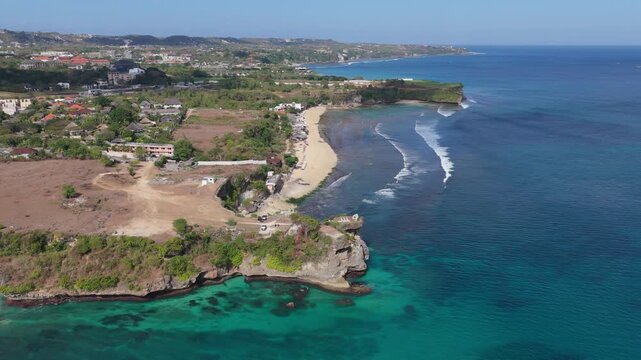 Biu Biu Beach in Jimbaran, Bali, Indonesia, features a secluded coastal setting with ocean views, rocky cliffs, sandy shoreline, and the scenic southern Bukit Peninsula