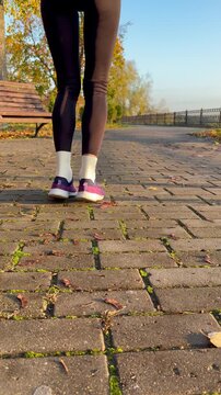 fitness, sports training, warm-up routines, and healthy lifestyle concepts. A woman doing calf raises and stretching in an autumn park.