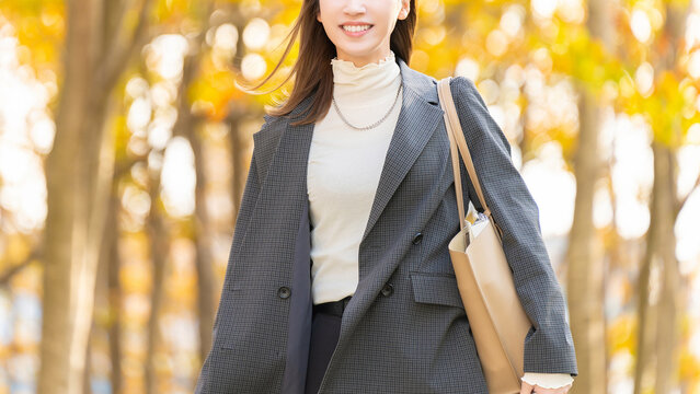 紅葉の街路樹と女性・ビジネスウーマン